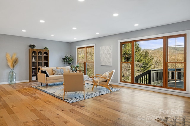 living room featuring light wood finished floors, recessed lighting, and a healthy amount of sunlight