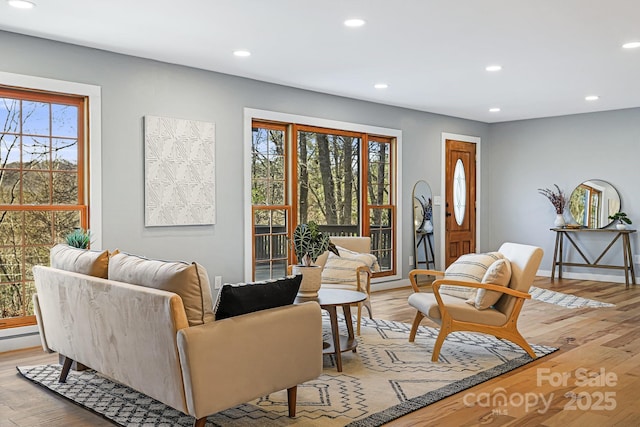 living room featuring baseboards, light wood-type flooring, and recessed lighting