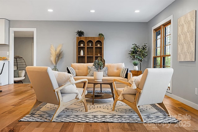 sitting room with light wood-style floors, recessed lighting, and baseboards