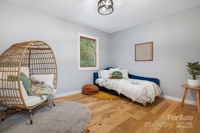 bedroom featuring baseboards and wood finished floors