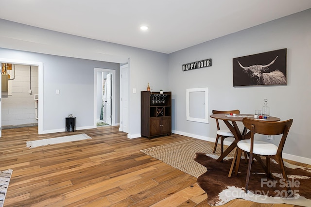 dining room featuring light wood-style floors, recessed lighting, and baseboards