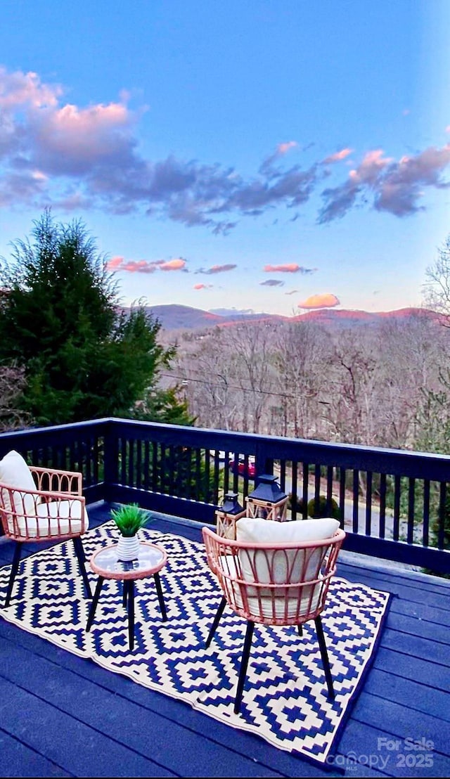 deck at dusk featuring a mountain view