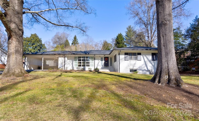 view of front facade featuring a front lawn and an attached carport