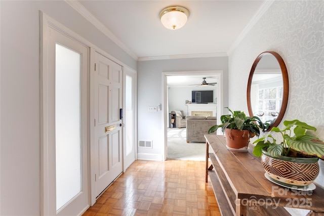 entryway featuring ornamental molding, a fireplace, and visible vents