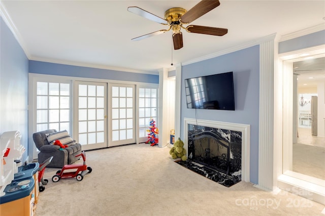 rec room featuring carpet floors, ornamental molding, a high end fireplace, and a healthy amount of sunlight