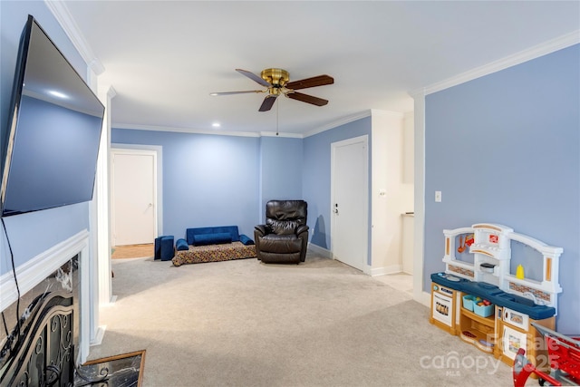 sitting room featuring light carpet, ornamental molding, and a ceiling fan