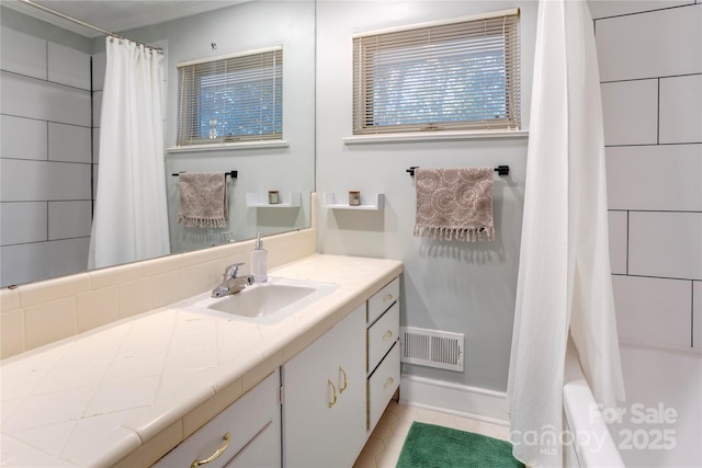 bathroom with shower / tub combo, vanity, visible vents, and tile patterned floors