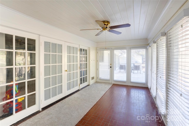 unfurnished sunroom with wooden ceiling and ceiling fan