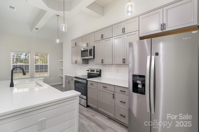 kitchen with visible vents, appliances with stainless steel finishes, a sink, gray cabinetry, and backsplash