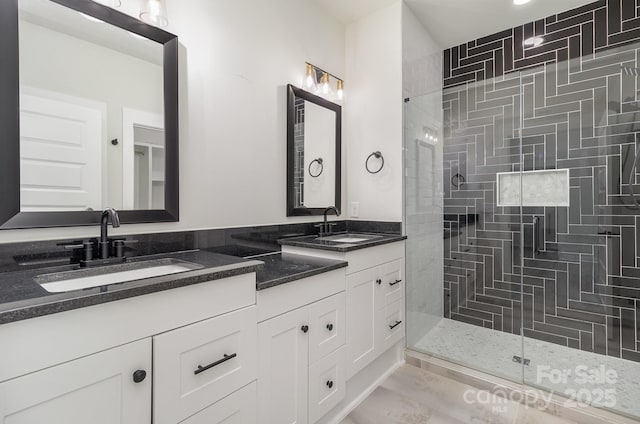 full bathroom with double vanity, a sink, and a shower stall