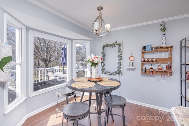 dining space with an inviting chandelier, crown molding, baseboards, and dark wood-type flooring