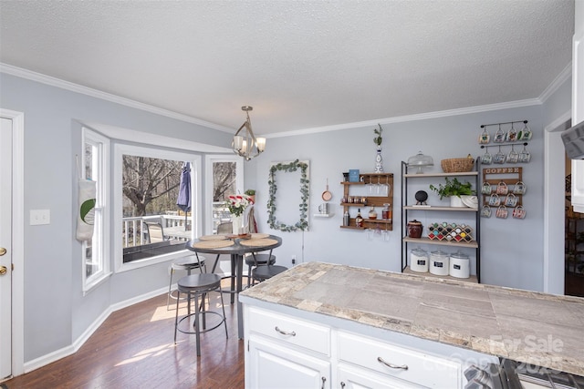 kitchen featuring dark wood-style flooring, decorative light fixtures, a notable chandelier, tile countertops, and white cabinetry