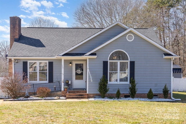 view of front of home with crawl space, roof with shingles, a chimney, and a front lawn