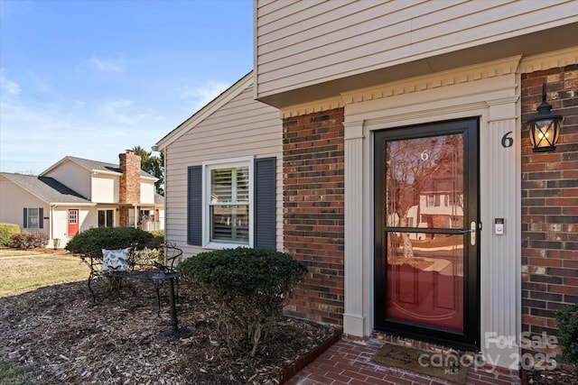 doorway to property with brick siding