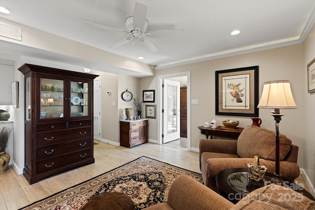 living area featuring light wood-style flooring, visible vents, and baseboards