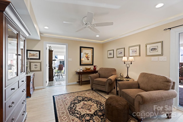 living area with light wood finished floors, baseboards, a ceiling fan, ornamental molding, and recessed lighting