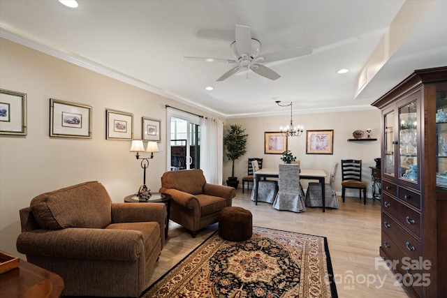 living room featuring ceiling fan with notable chandelier, light wood-style floors, recessed lighting, and crown molding