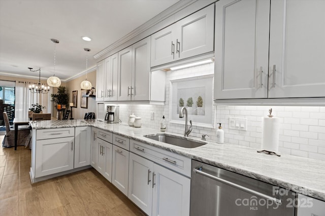 kitchen featuring a peninsula, a sink, light stone countertops, pendant lighting, and stainless steel dishwasher