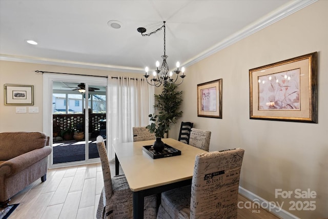 dining area with a chandelier, ornamental molding, light wood-style floors, and baseboards