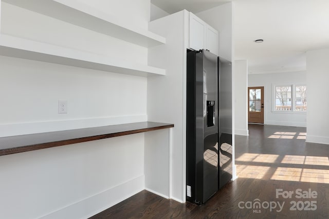 kitchen with dark wood-style flooring, baseboards, white cabinets, stainless steel fridge with ice dispenser, and open shelves