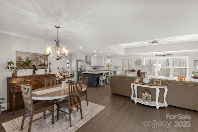 dining room featuring ceiling fan with notable chandelier, dark wood-type flooring, ornamental molding, and a wealth of natural light