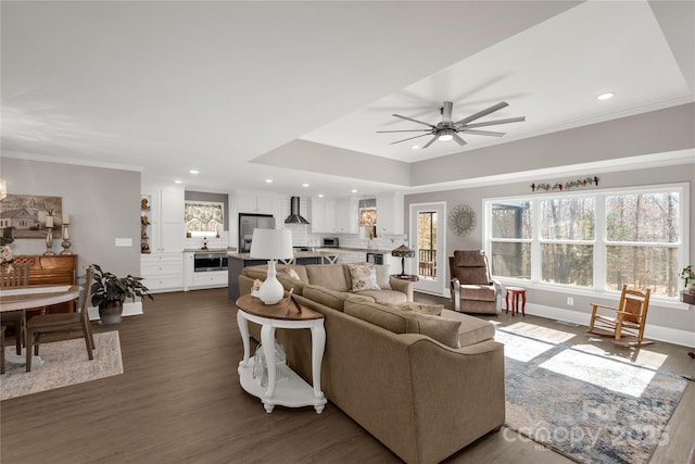 living area featuring dark wood finished floors, crown molding, recessed lighting, ceiling fan, and baseboards