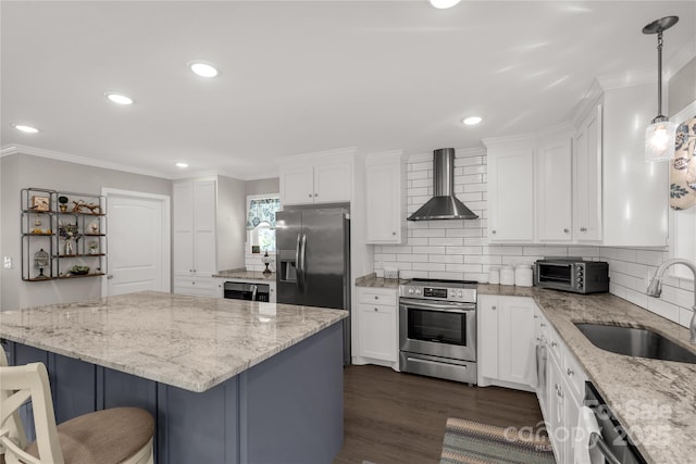 kitchen with stainless steel appliances, white cabinets, a sink, and wall chimney exhaust hood