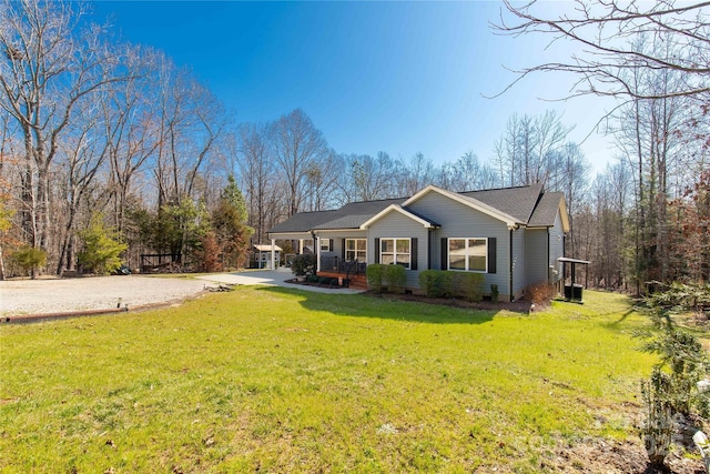 view of front of property with covered porch, driveway, a front yard, and central air condition unit