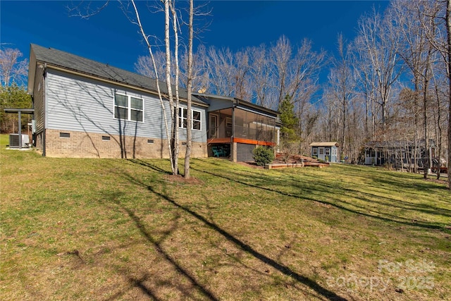 back of house featuring crawl space, a sunroom, central air condition unit, and a lawn