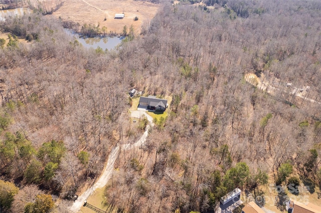 drone / aerial view featuring a water view and a wooded view