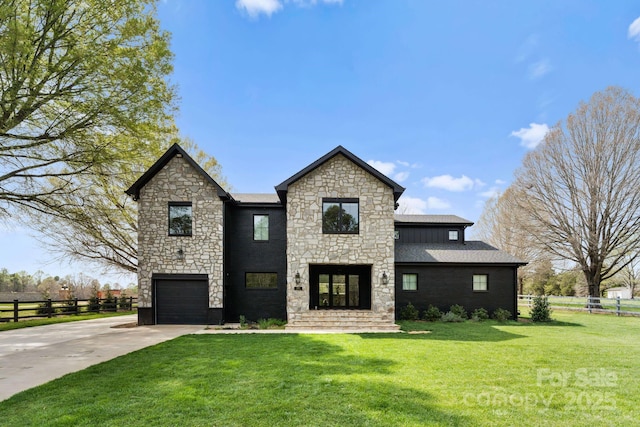 view of front facade featuring a front yard, fence, driveway, and an attached garage