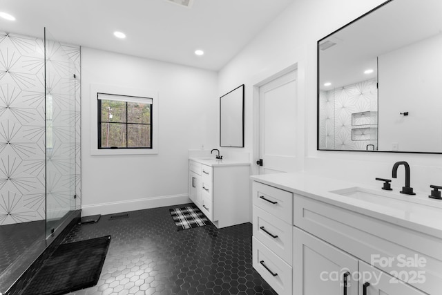 bathroom featuring recessed lighting, two vanities, a stall shower, a sink, and baseboards