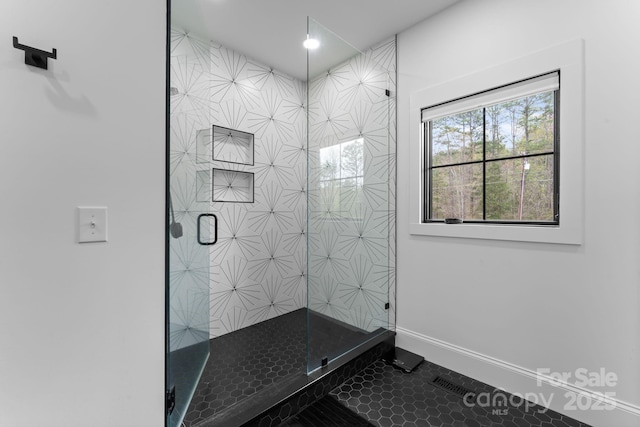 bathroom with a stall shower and baseboards