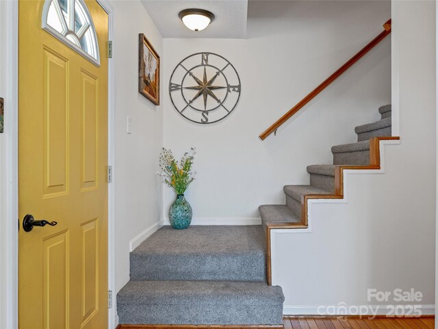 interior space featuring carpet floors, stairs, and baseboards