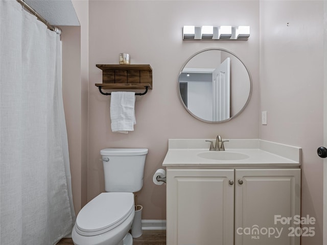 full bath with toilet, baseboards, and vanity