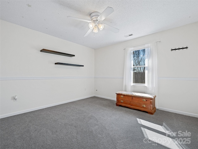 spare room featuring carpet flooring, ceiling fan, a textured ceiling, and baseboards