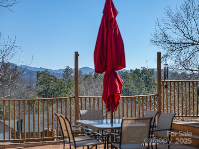 deck featuring outdoor dining space and a mountain view