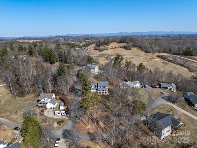 drone / aerial view featuring a mountain view and a view of trees