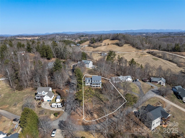 drone / aerial view featuring a mountain view and a forest view