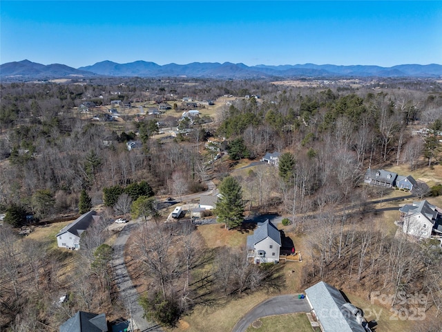 birds eye view of property with a mountain view and a wooded view