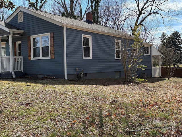 view of home's exterior featuring a shingled roof, crawl space, and a chimney