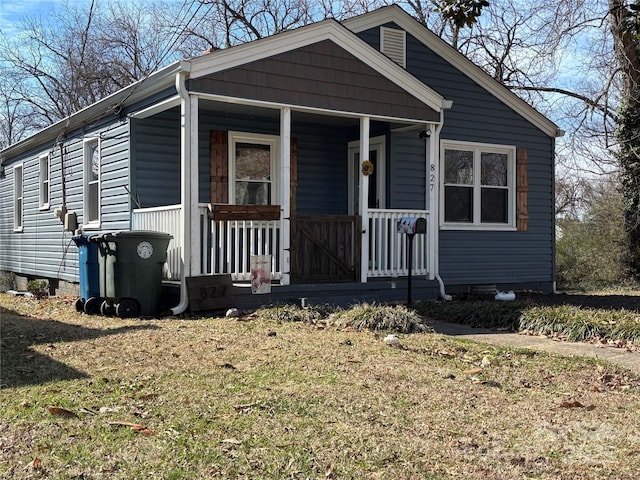 bungalow-style home featuring covered porch and a front yard