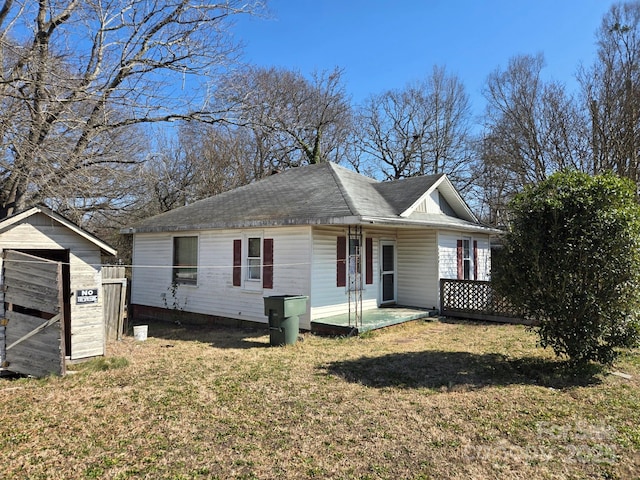 view of front of house featuring a storage unit, an outdoor structure, and a front yard