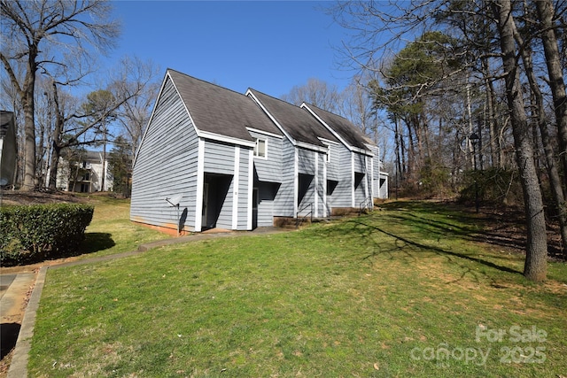 view of side of property featuring a lawn and roof with shingles