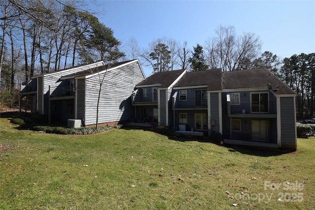 rear view of house with a lawn and a balcony