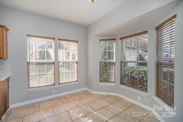 unfurnished dining area with baseboards