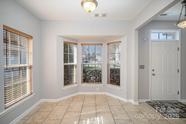 foyer with a wealth of natural light, visible vents, and baseboards