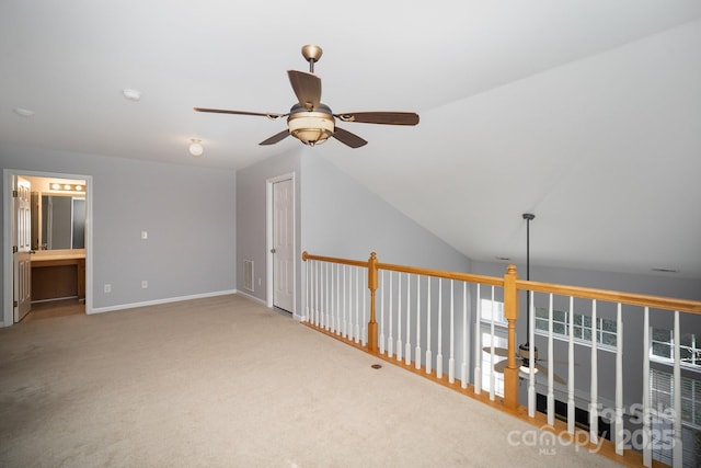 interior space featuring lofted ceiling, carpet, visible vents, and baseboards