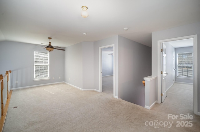 hall featuring baseboards, light colored carpet, and an upstairs landing