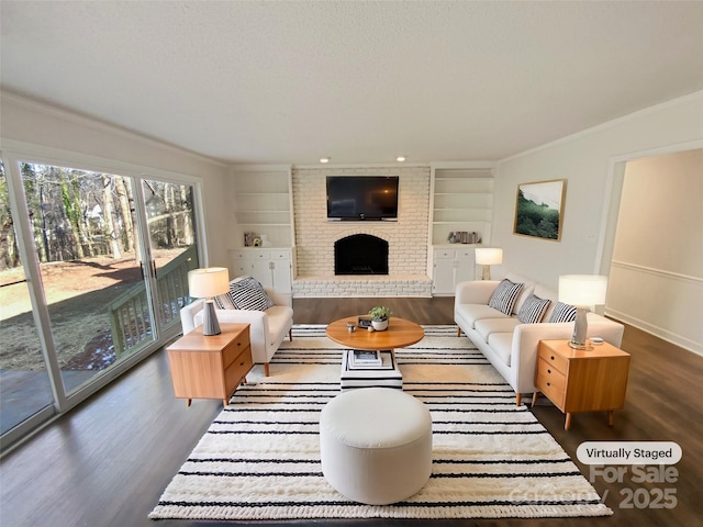 living area featuring ornamental molding, a brick fireplace, wood finished floors, and built in features